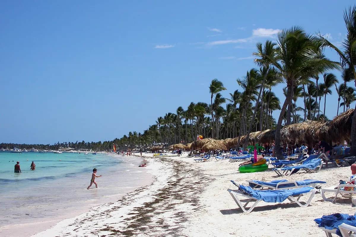 Playa de arena blanca con palmeras y mar turquesa en Punta Cana